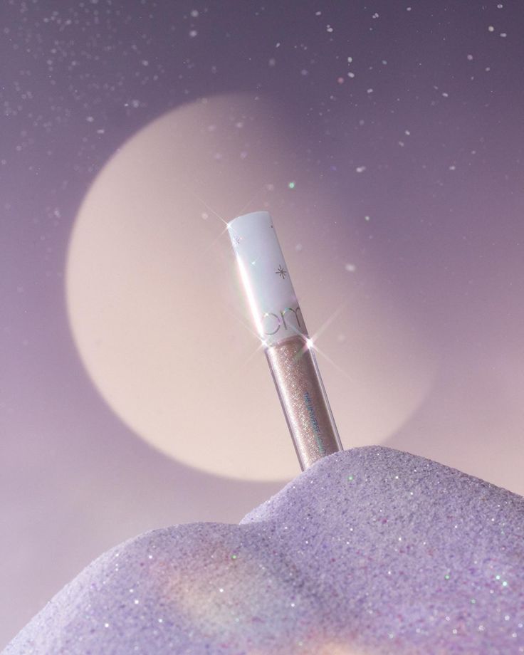 Romand The Universe Liquid Glitter on purple lavender background with mystic aura. Korean high-sparkle softeye glitter, long-wear formula, authentic and available at Sejou Lebanon. Give baby eyes look. 